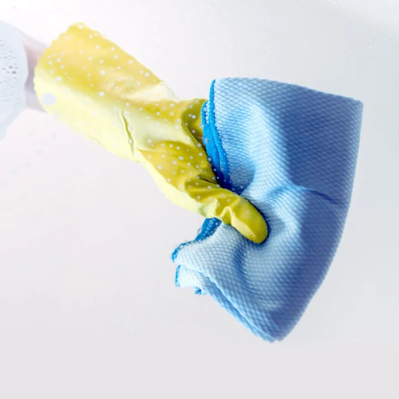 Gloved hand cleaning with a blue cloth Gloved hand cleaning with a blue cloth
