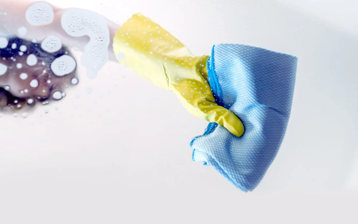 Gloved hand cleaning with a blue cloth Gloved hand cleaning with a blue cloth